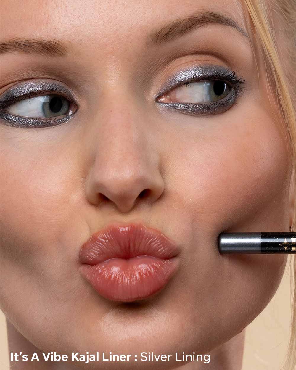 Close-up of a woman applying silver kajal liner with a brush, featuring 'It's A Vibe Kajal Liner'.